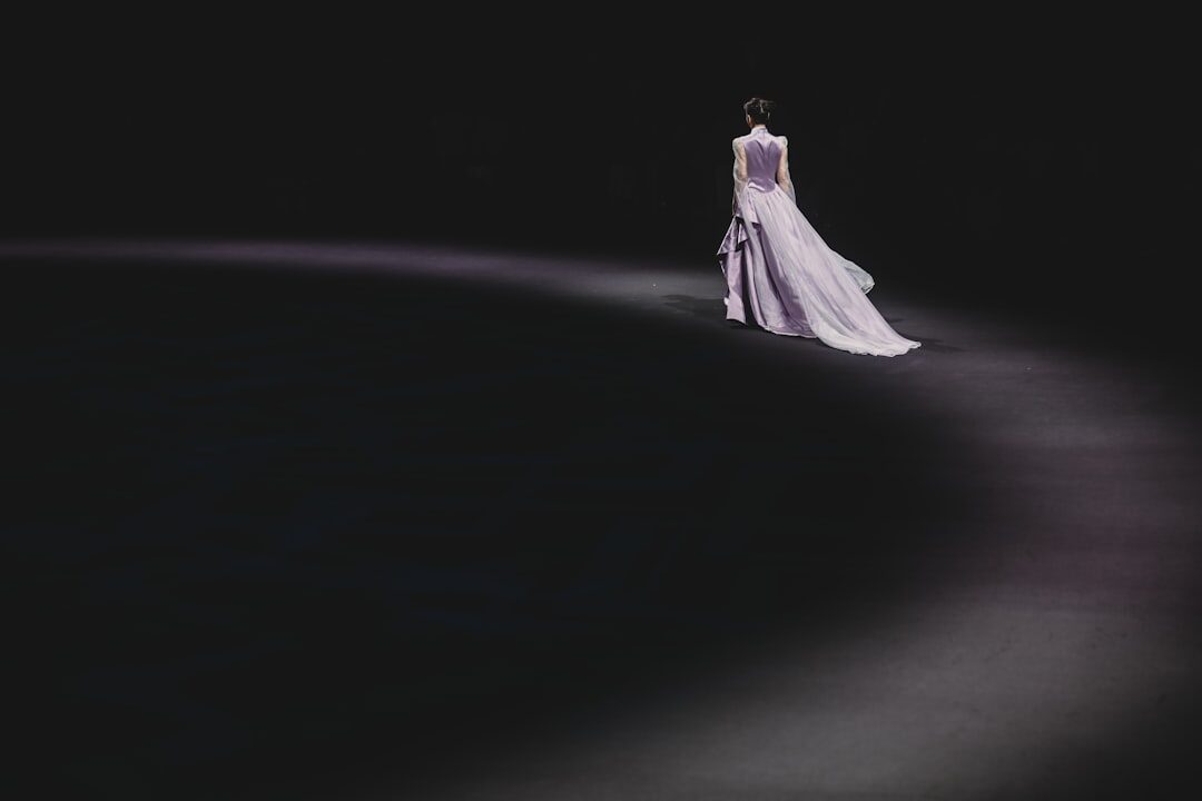 Archival fashion runway with soft spotlight and empty front row seating